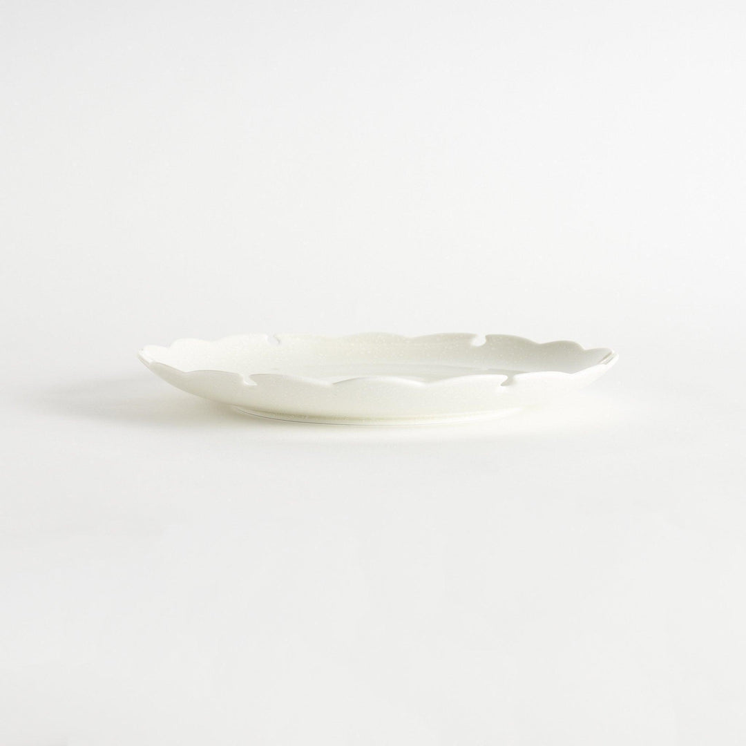 Ceramic dinner plates with scalloped edges, available in black and white.