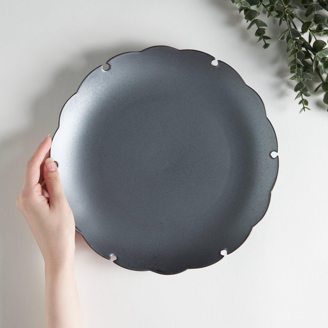 Ceramic dinner plates with scalloped edges, available in black and white.