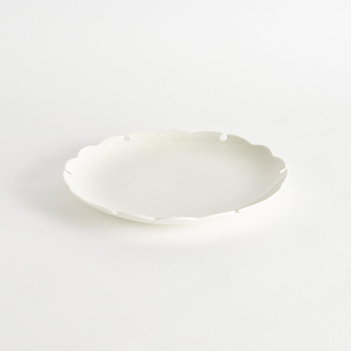 Ceramic dinner plates with scalloped edges, available in black and white.