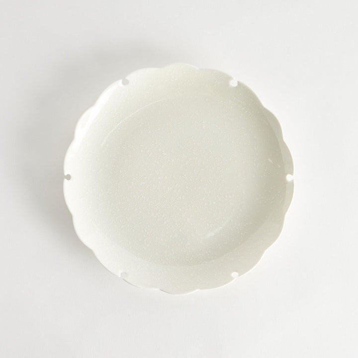 Ceramic dinner plates with scalloped edges, available in black and white.