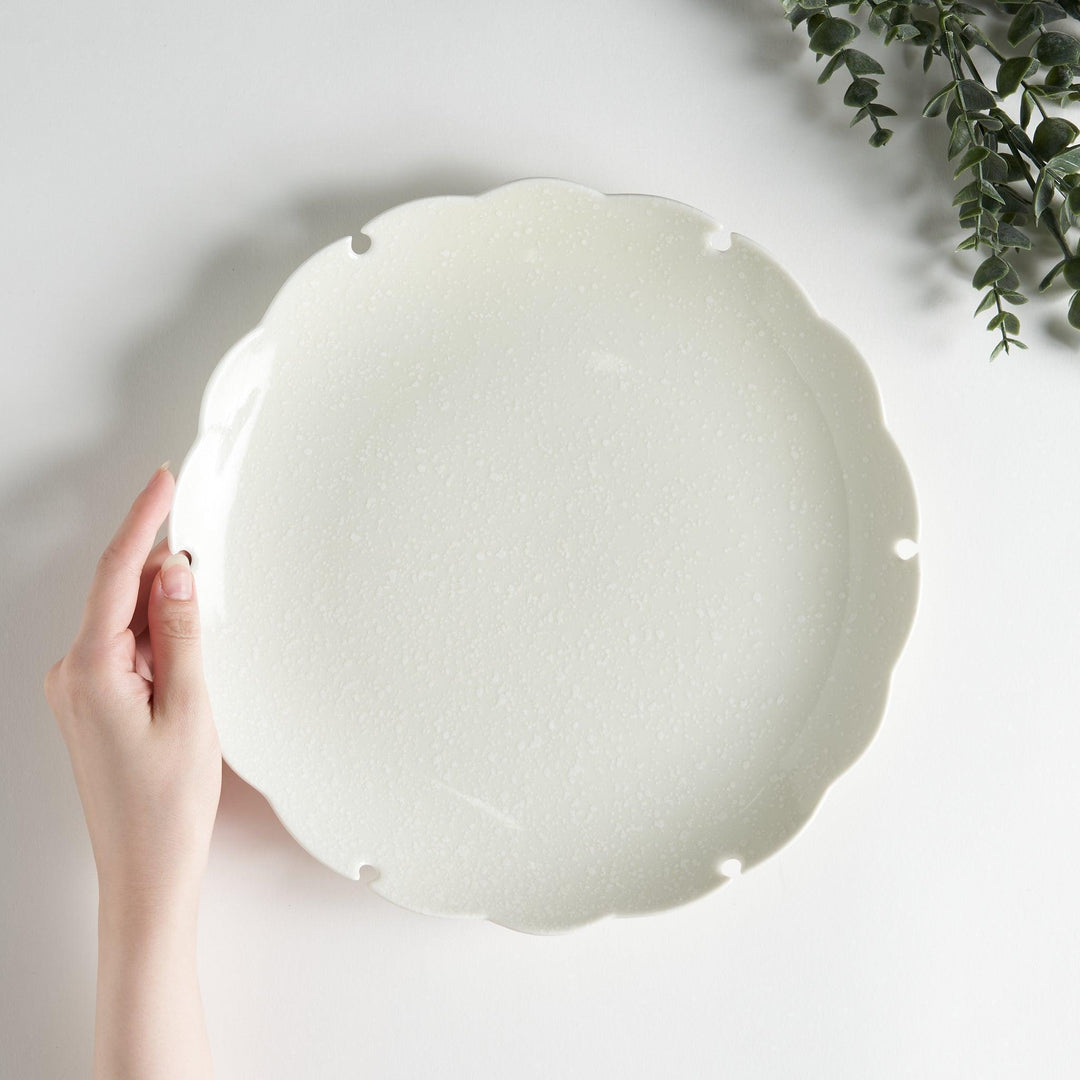 Ceramic dinner plates with scalloped edges, available in black and white.