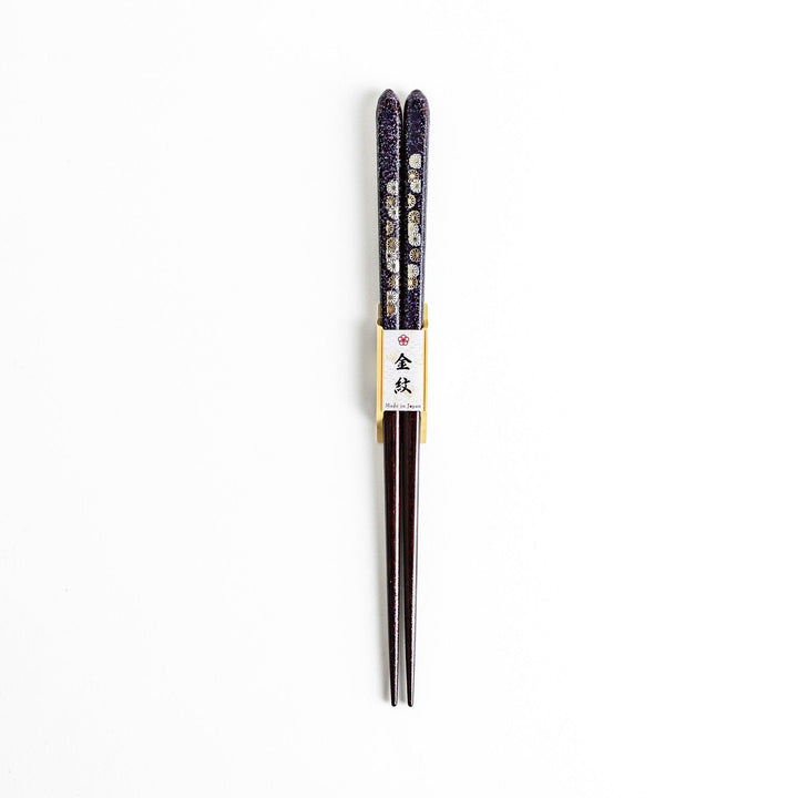 Two pairs of chopsticks, one in deep purple and the other in red, each decorated with subtle gold accents and a speckled finish.