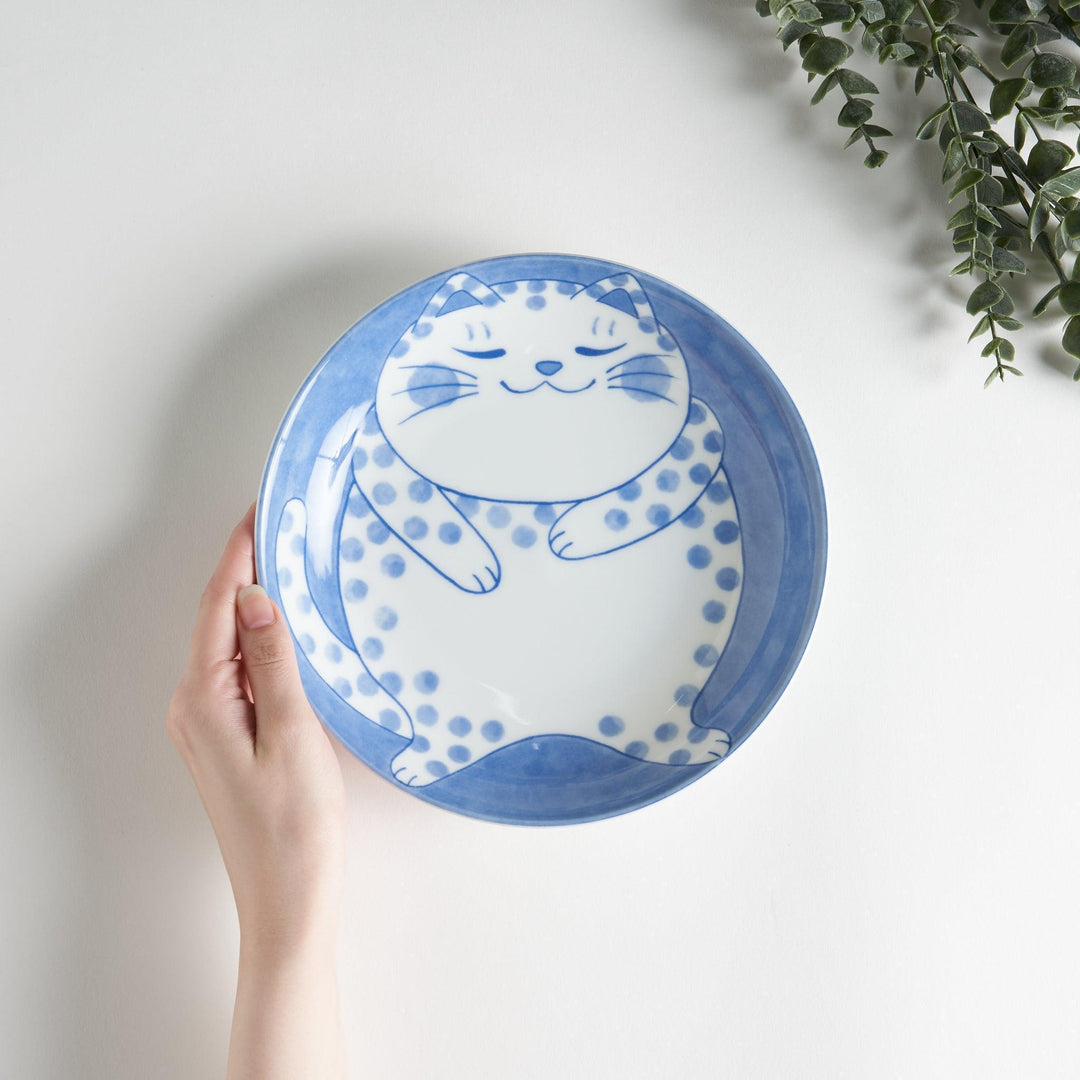 A salad plate featuring a chubby blue-spotted white cat with a contented expression.