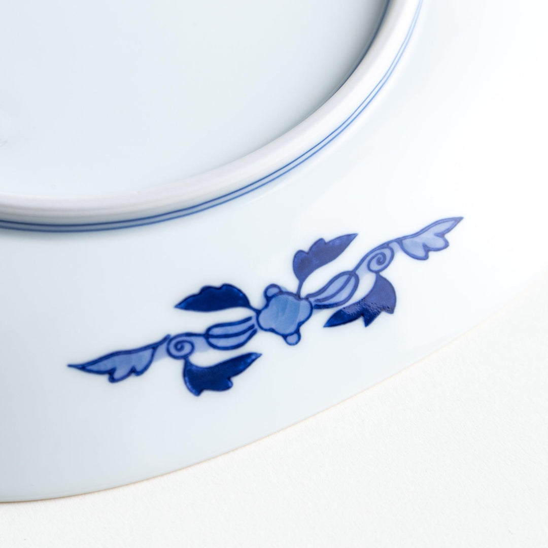 A square salad plate featuring a traditional Japanese landscape with trees, clouds, and maple leaves, framed by intricate blue and red patterns.