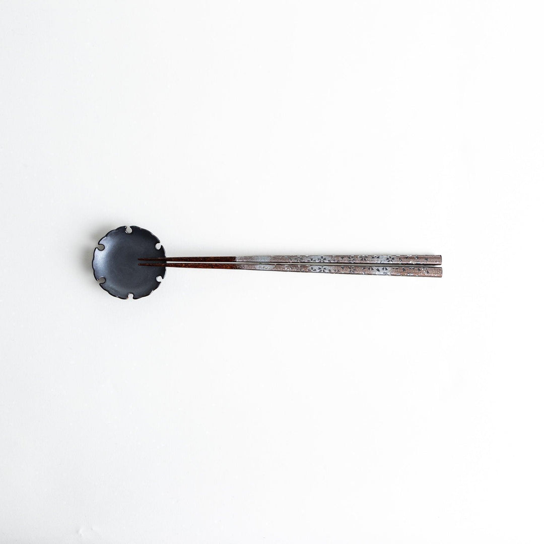 A pair of wooden chopsticks with a faded white gradient and delicate flower patterns near the top.