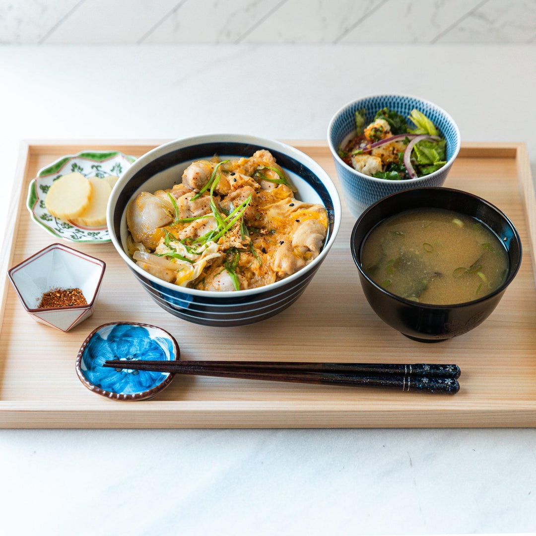 Medium-sized blue or red donburi bowl with thin horizontal white stripes and a matching dark base.