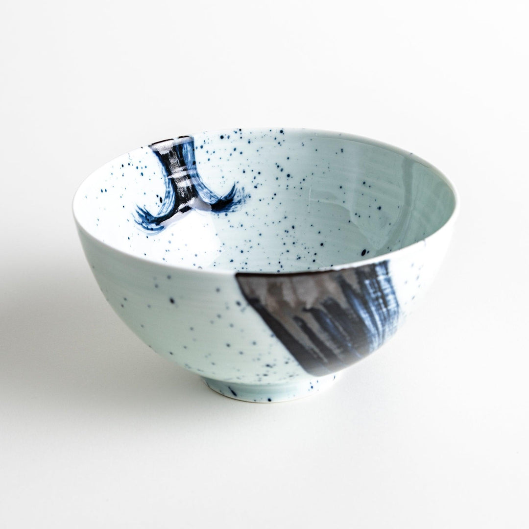 A white ceramic bowl with a striking blue brush stroke pattern.