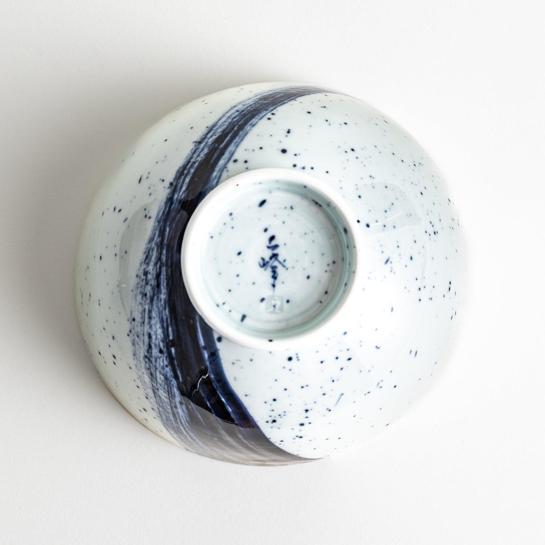 A white ceramic bowl with a striking blue brush stroke pattern.