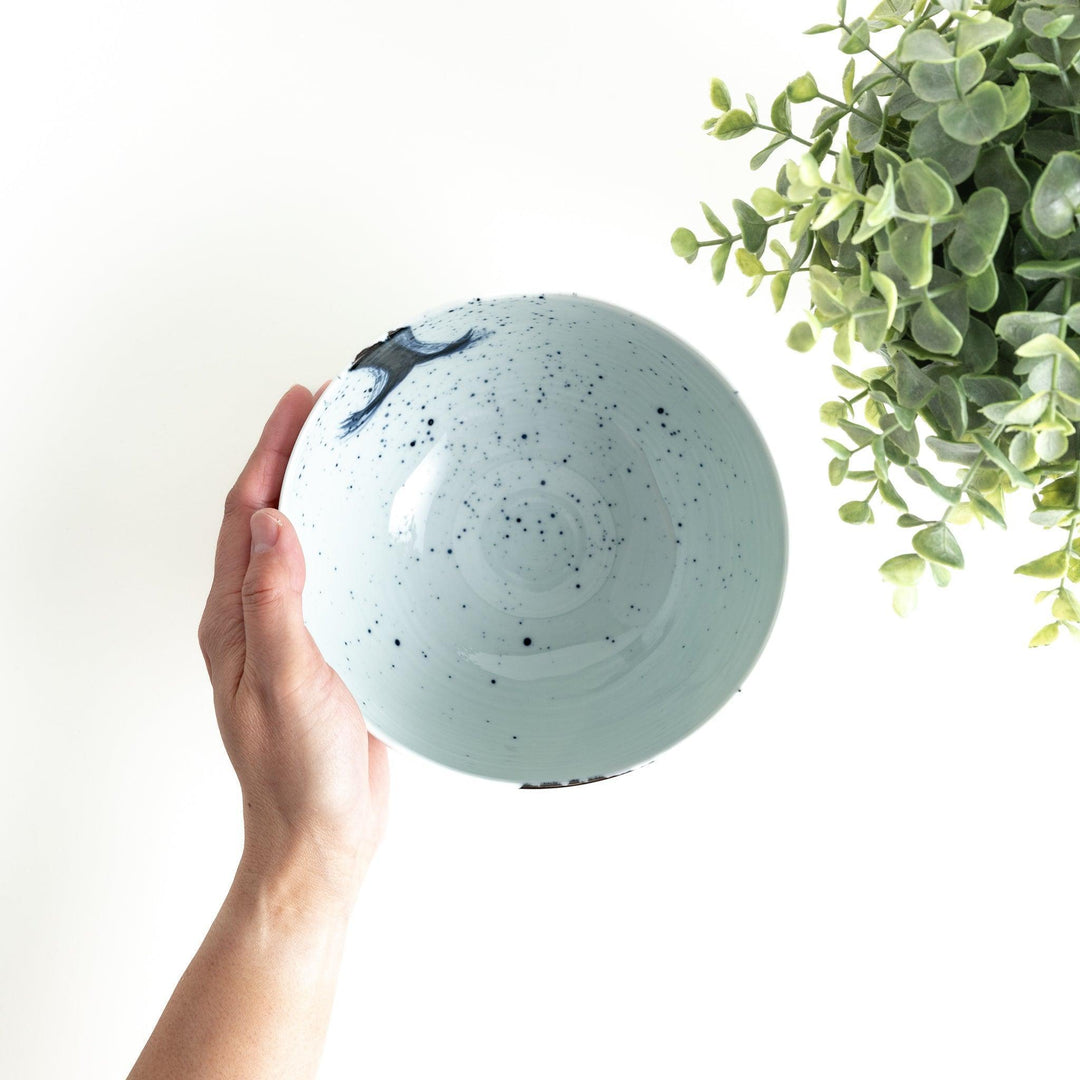 A white ceramic bowl with a striking blue brush stroke pattern.