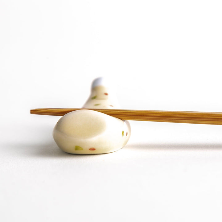 A ceramic chopstick rest resembling a tartar sauce bottle.