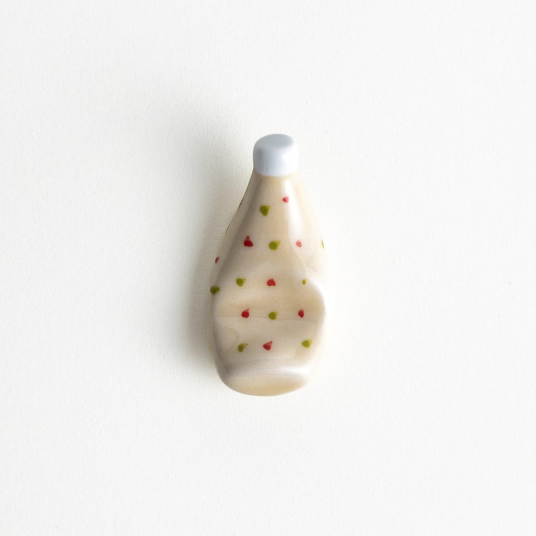 A ceramic chopstick rest resembling a tartar sauce bottle.