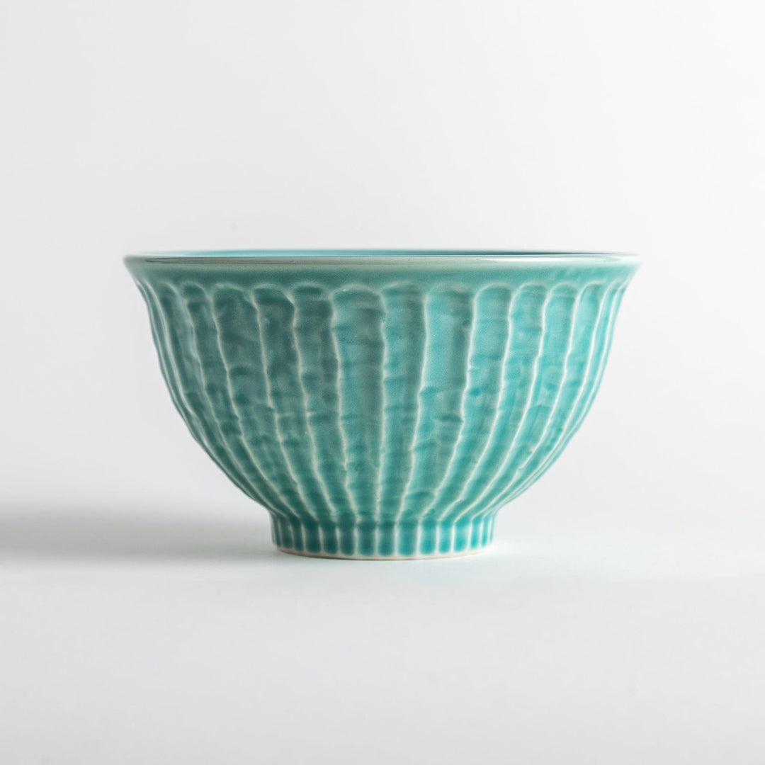 A light turquoise ceramic rice bowl with a natural, rustic texture and a ribbed design.