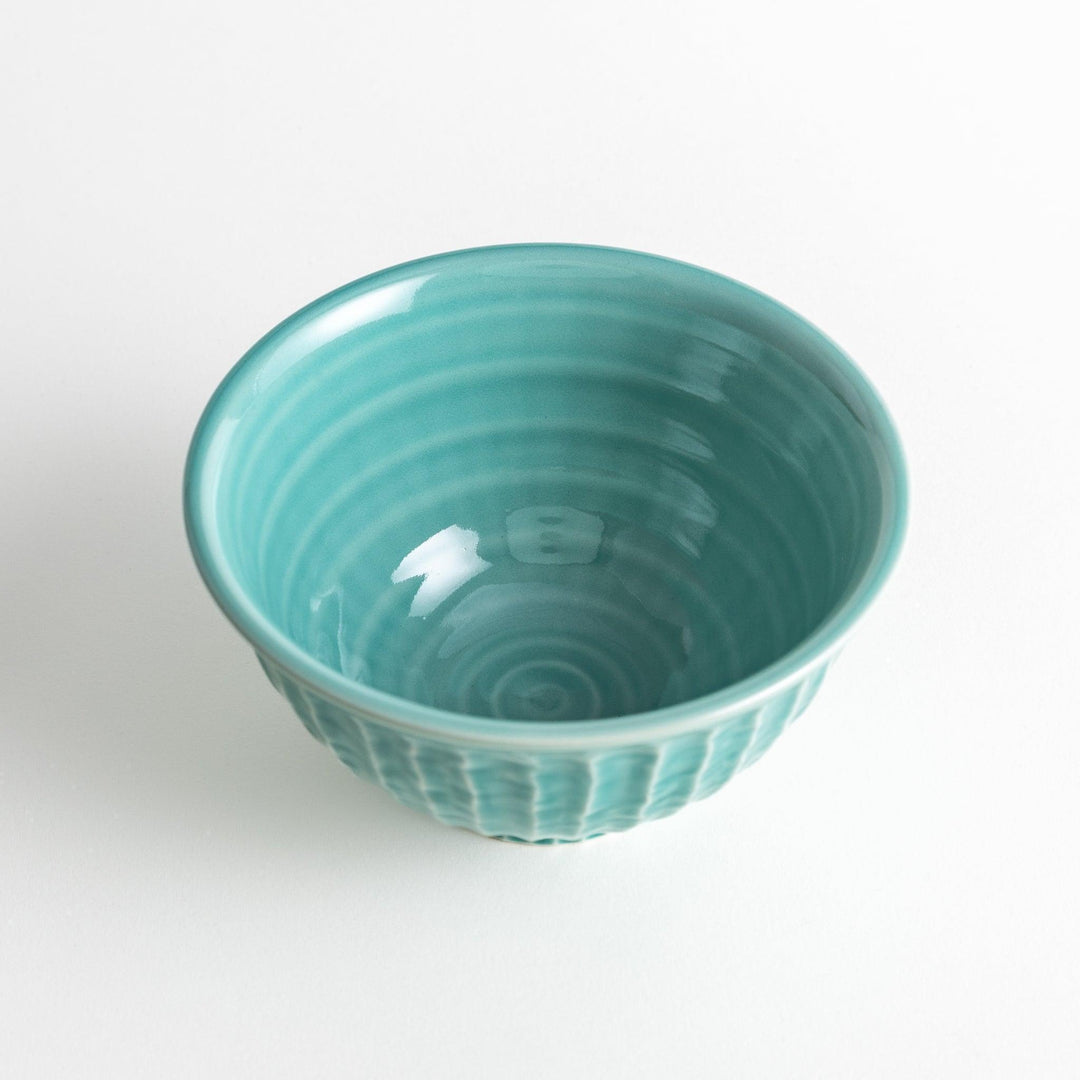 A light turquoise ceramic rice bowl with a natural, rustic texture and a ribbed design.