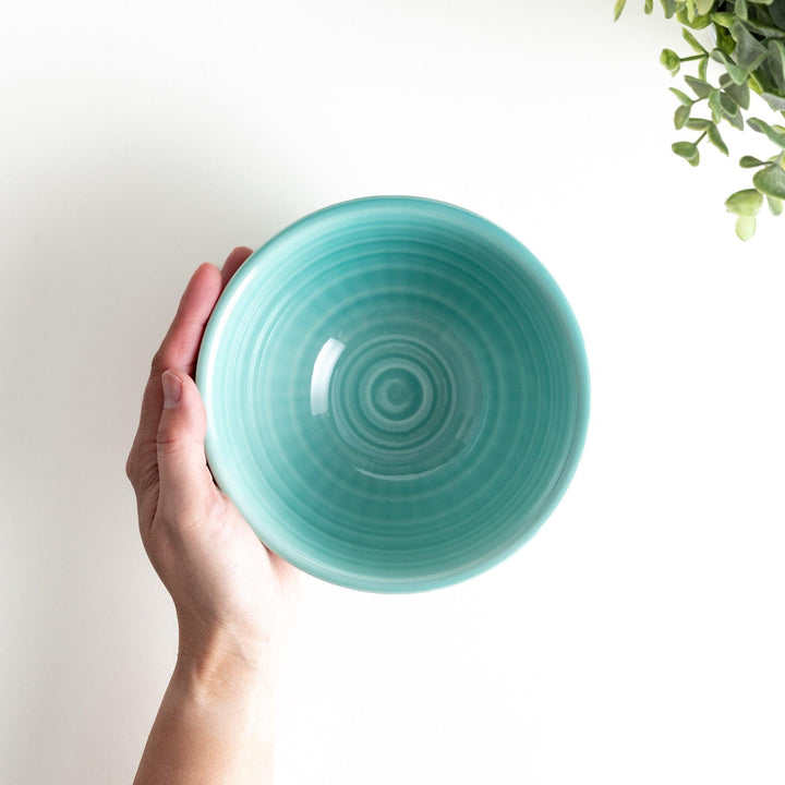 A light turquoise ceramic rice bowl with a natural, rustic texture and a ribbed design.