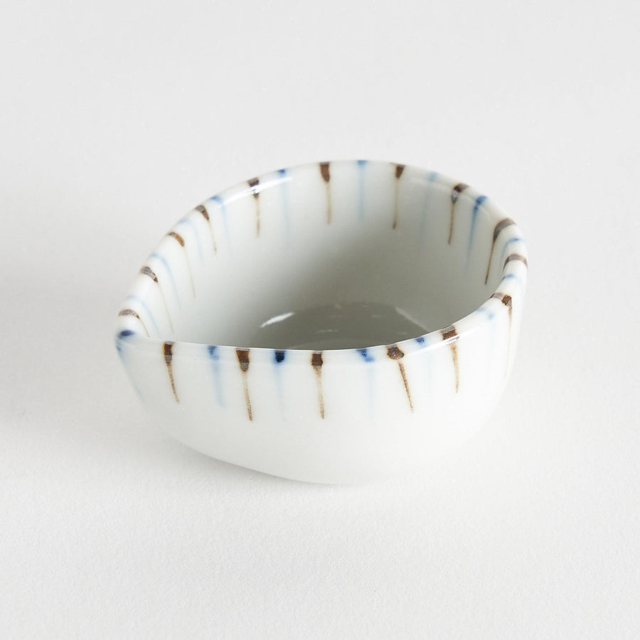 A small, curved condiment bowl featuring vertical blue and brown stripes.