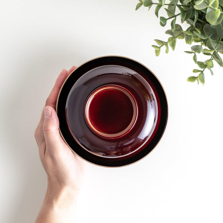 A glossy lacquer bowl with a matching lid, featuring a gold rim around the edge, ideal for serving soups or stews. Available in black or red.