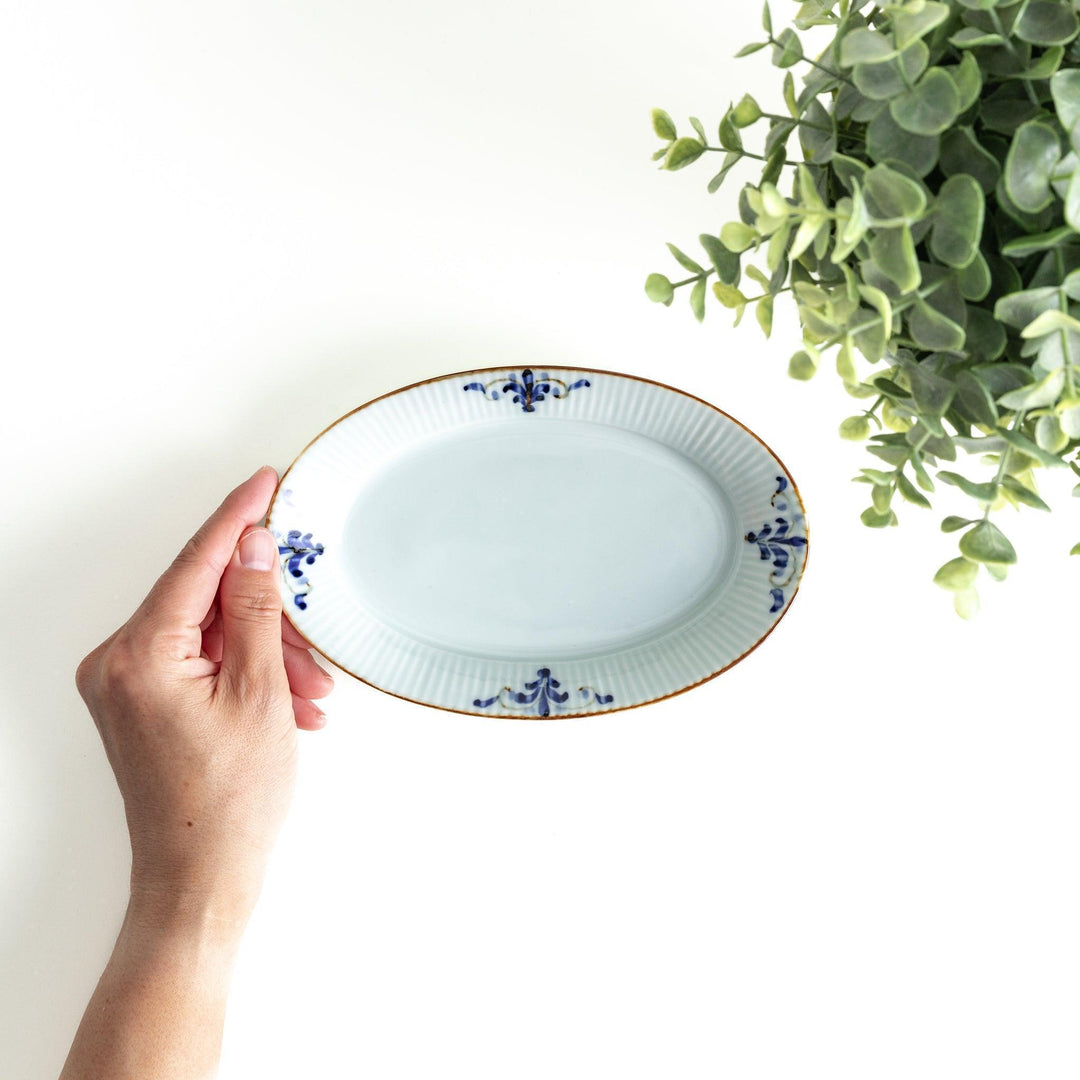 A small oval porcelain plate with subtle blue floral accents on the edges.