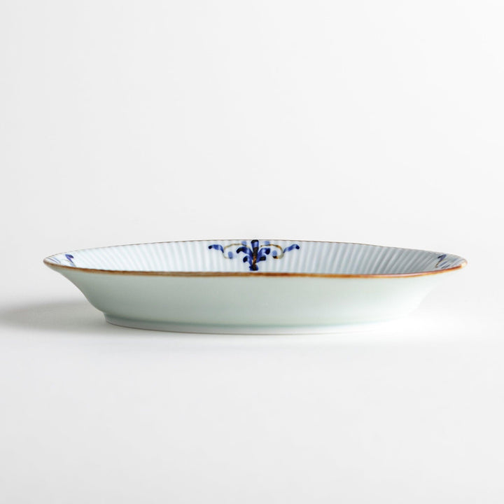 A small oval porcelain plate with subtle blue floral accents on the edges.