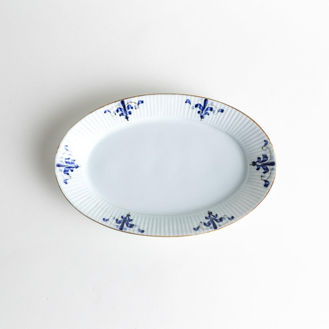 A medium-sized oval porcelain plate adorned with blue floral designs on the edges.