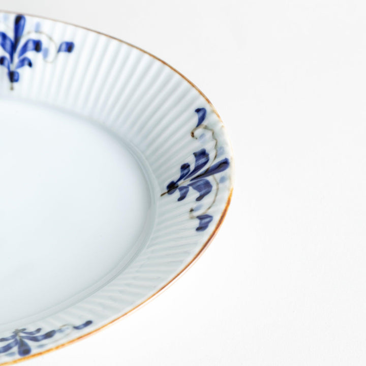 A medium-sized oval porcelain plate adorned with blue floral designs on the edges.