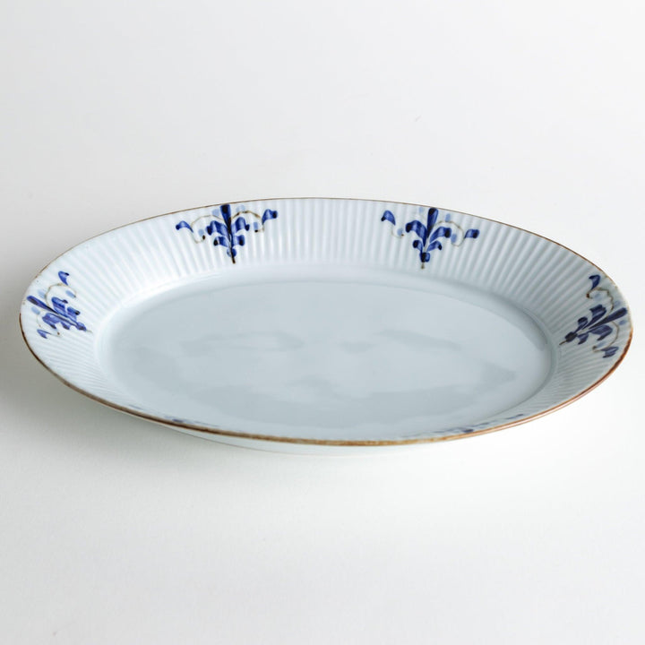 A medium-sized oval porcelain plate adorned with blue floral designs on the edges.