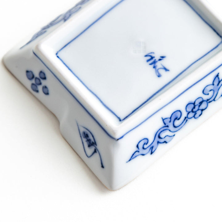 Rectangular plate with a blue landscape pattern and geometric design.