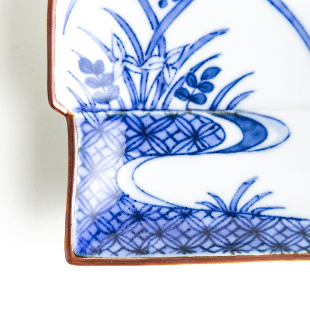 Rectangular plate with a blue landscape pattern and geometric design.