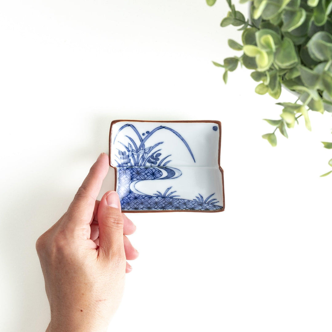 Rectangular plate with a blue landscape pattern and geometric design.