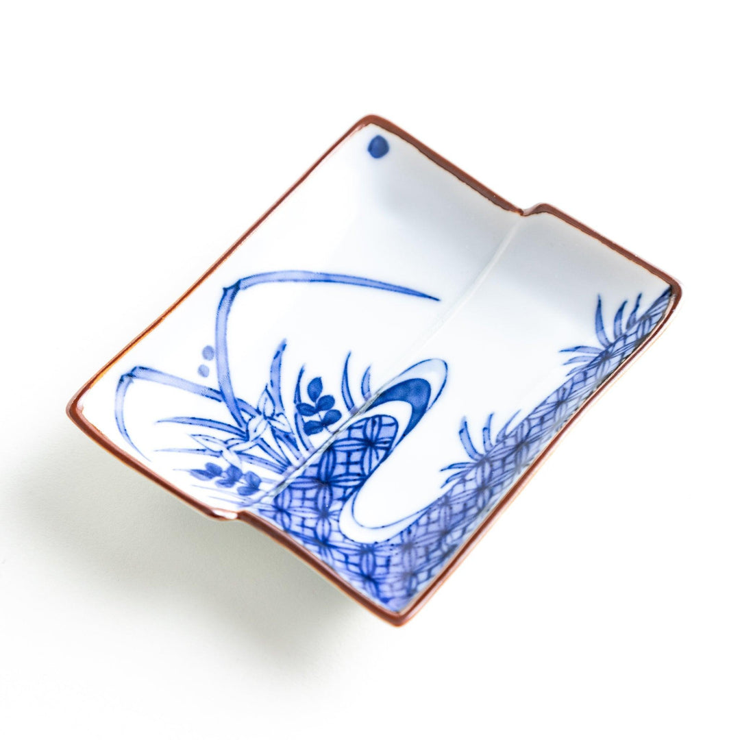 Rectangular plate with a blue landscape pattern and geometric design.