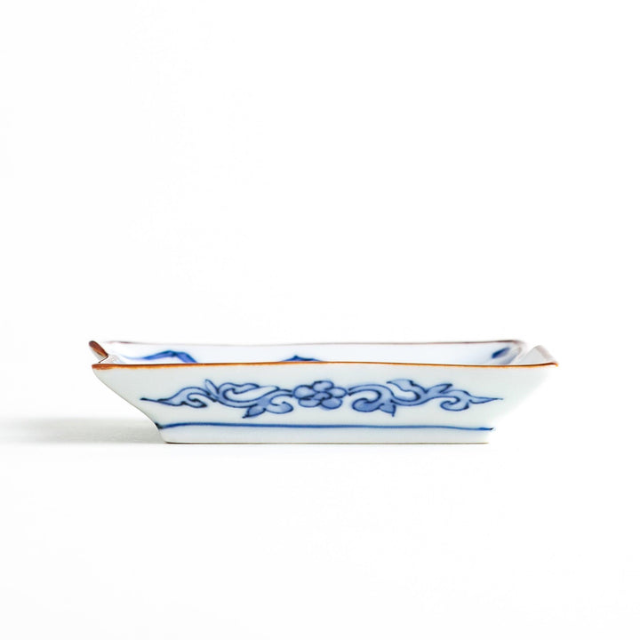 Rectangular plate with a blue landscape pattern and geometric design.