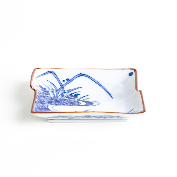 Rectangular plate with a blue landscape pattern and geometric design.