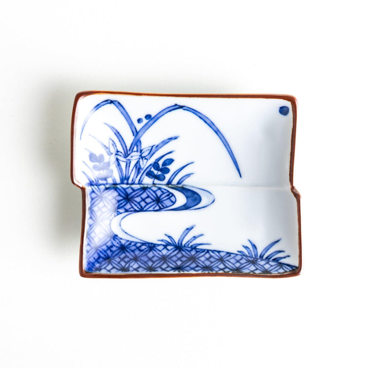 Rectangular plate with a blue landscape pattern and geometric design.