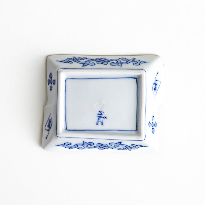 Rectangular plate with a blue landscape pattern and geometric design.