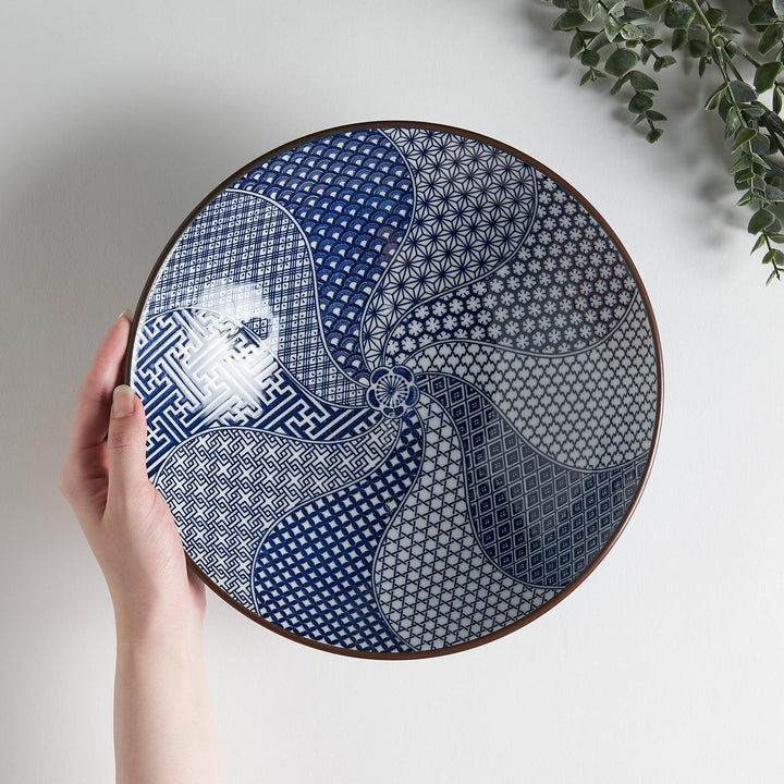 A bowl with a deep blue exterior and a segmented interior featuring various traditional blue patterns.