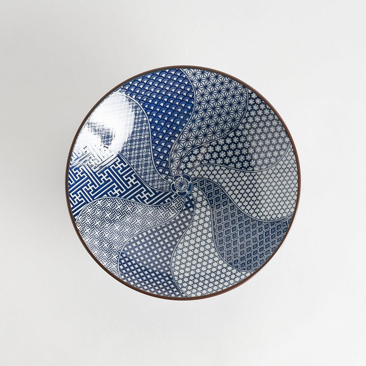 A bowl with a deep blue exterior and a segmented interior featuring various traditional blue patterns.