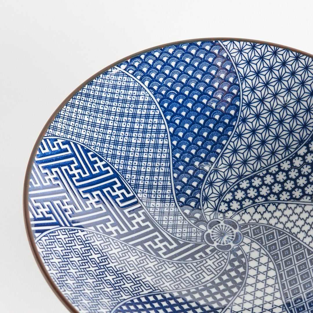 A bowl with a deep blue exterior and a segmented interior featuring various traditional blue patterns.