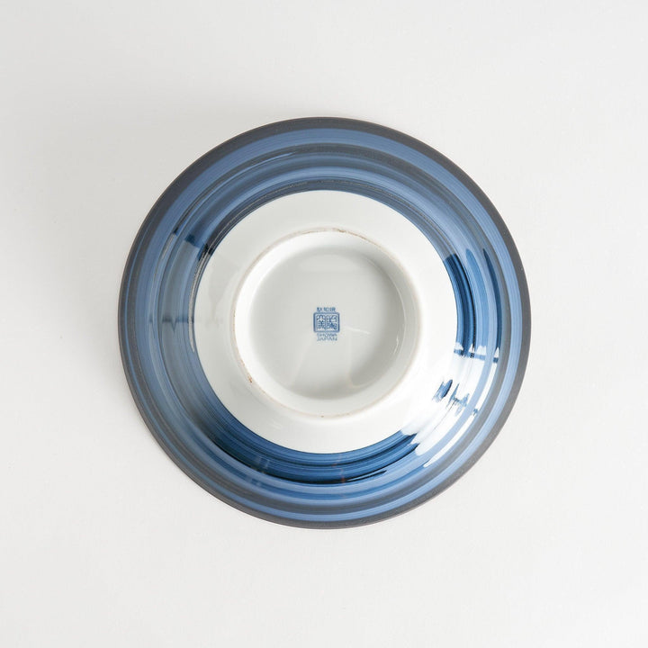 A bowl with a deep blue exterior and a segmented interior featuring various traditional blue patterns.