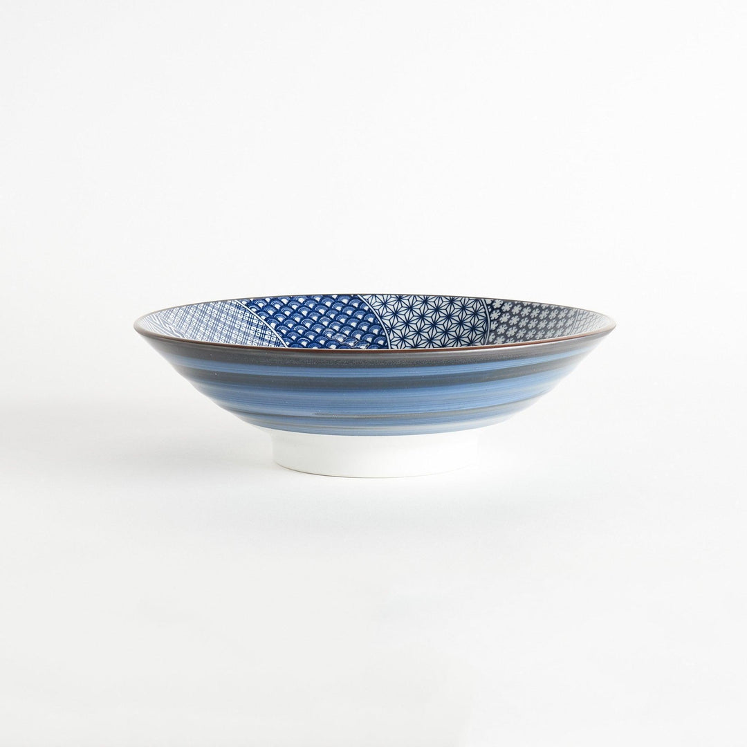 A bowl with a deep blue exterior and a segmented interior featuring various traditional blue patterns.