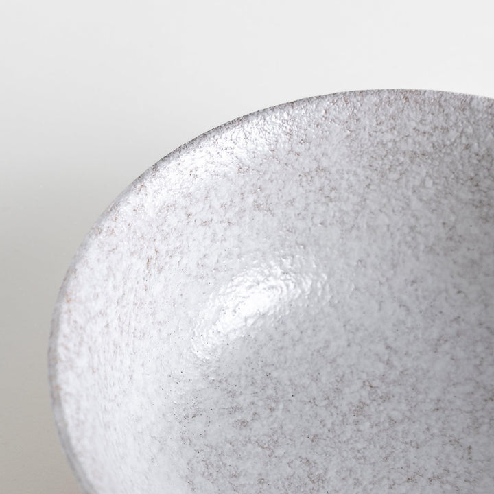 A bowl with a textured, speckled white glaze and a natural, earthy appearance.