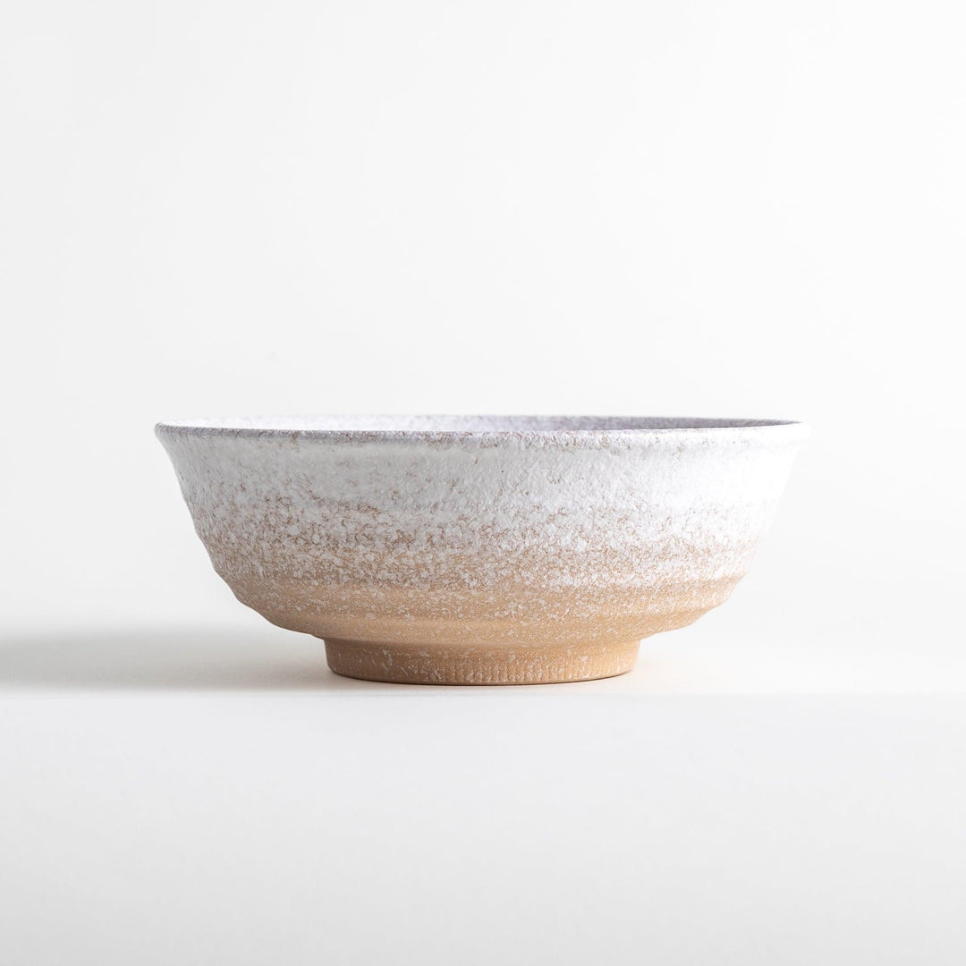 A bowl with a textured, speckled white glaze and a natural, earthy appearance.