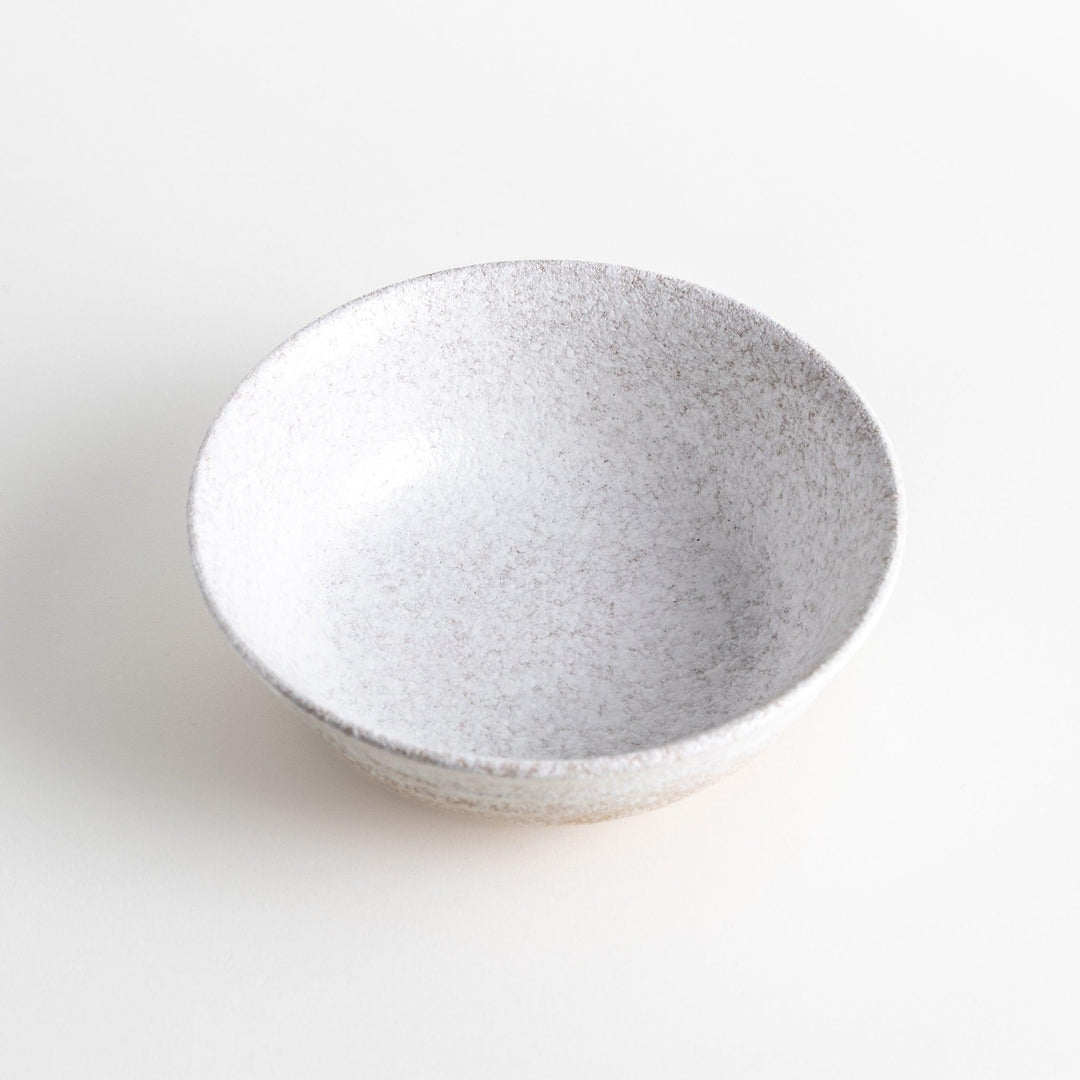 A bowl with a textured, speckled white glaze and a natural, earthy appearance.