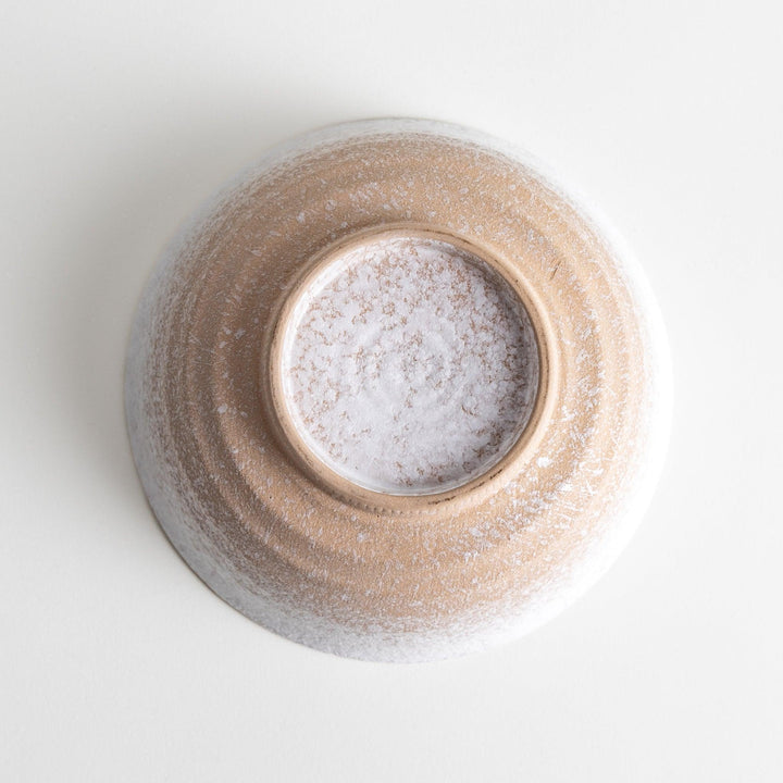 A bowl with a textured, speckled white glaze and a natural, earthy appearance.