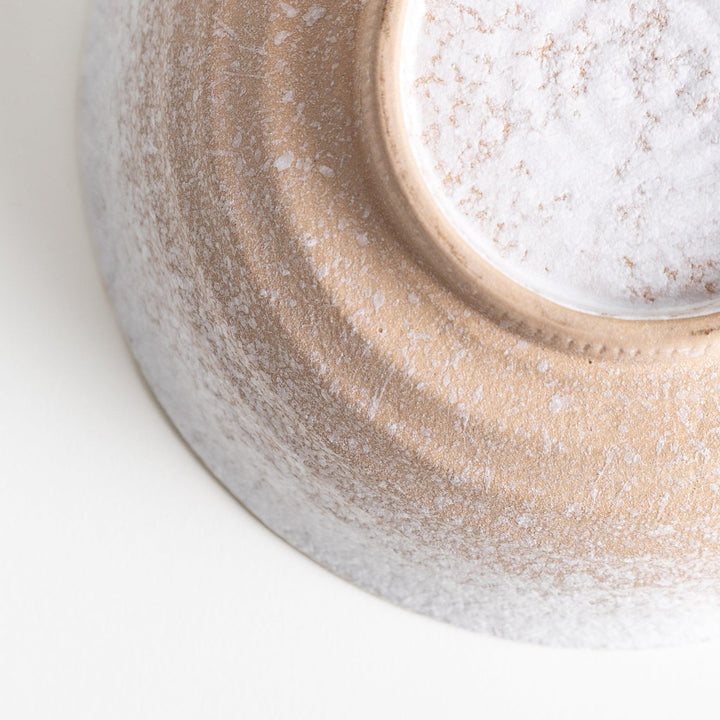 A bowl with a textured, speckled white glaze and a natural, earthy appearance.