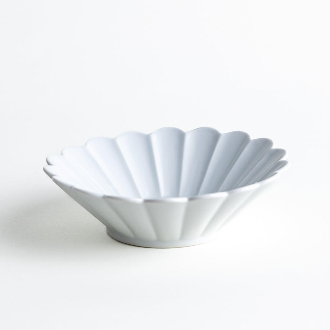 A white ceramic bowl featuring a fluted design.