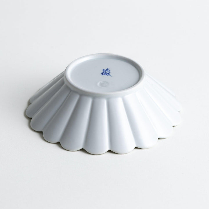 A white ceramic bowl featuring a fluted design.