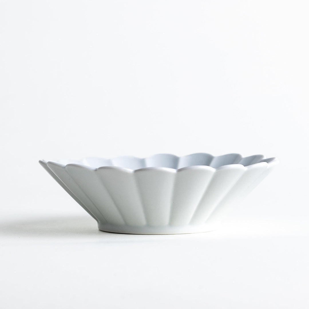 A white ceramic bowl featuring a fluted design.