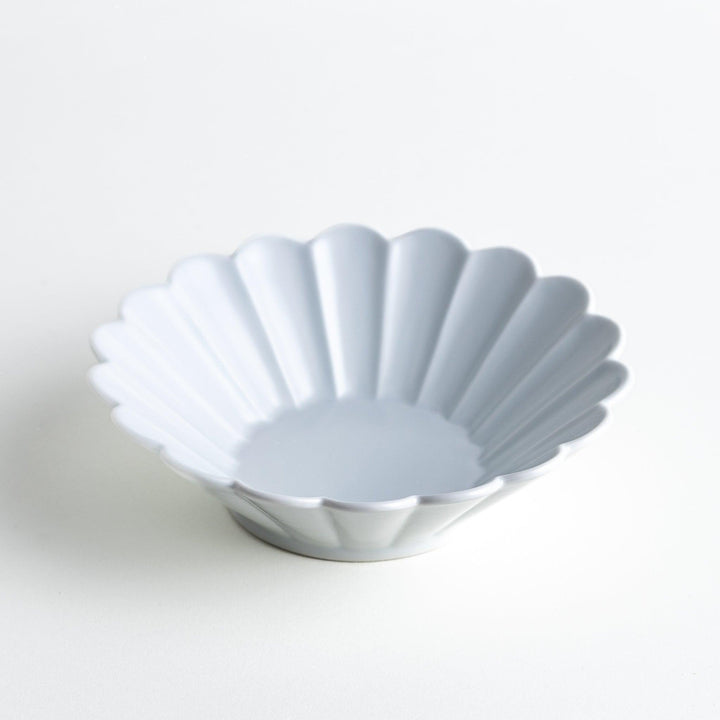 A white ceramic bowl featuring a fluted design.