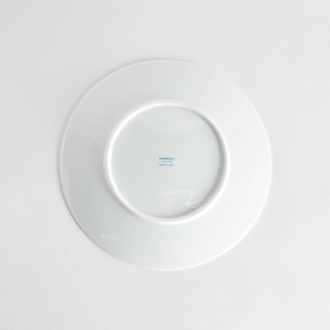 A simple white dinner plate with a subtle texture.