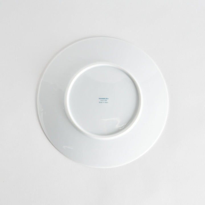 A simple white dinner plate with a subtle texture.