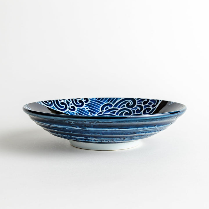 A pasta bowl decorated with blue and white whales and waves.